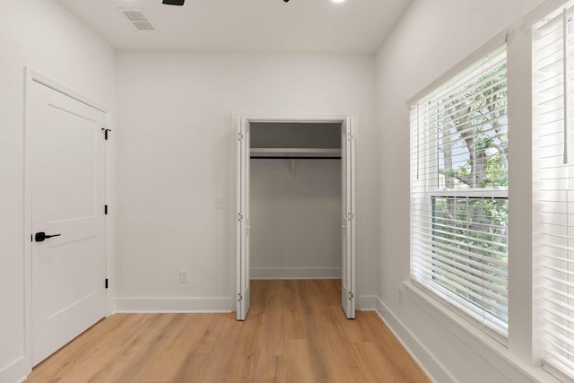 866 Tripe St, Charleston, SC 29407 - unfurnished bedroom with light wood-style flooring, a spacious closet, multiple windows, and baseboards