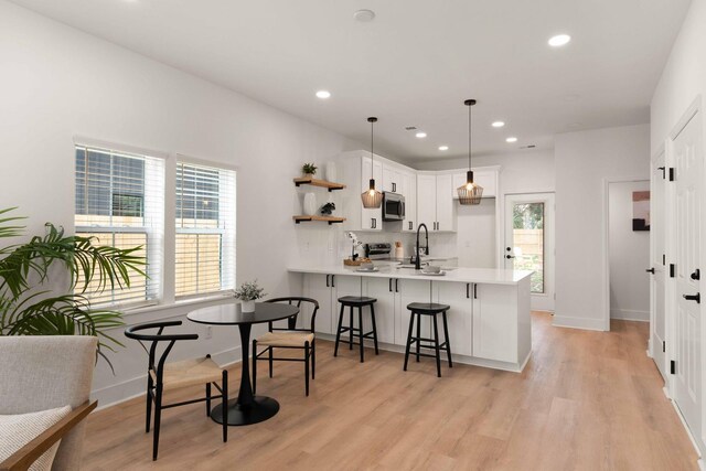 866 Tripe St, Charleston, SC 29407 - kitchen featuring stainless steel microwave, a peninsula, light countertops, white cabinets, and open shelves