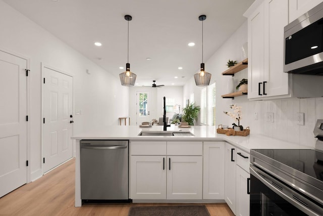 866 Tripe St, Charleston, SC 29407 - kitchen featuring stainless steel appliances, a sink, a peninsula, white cabinetry, and light countertops