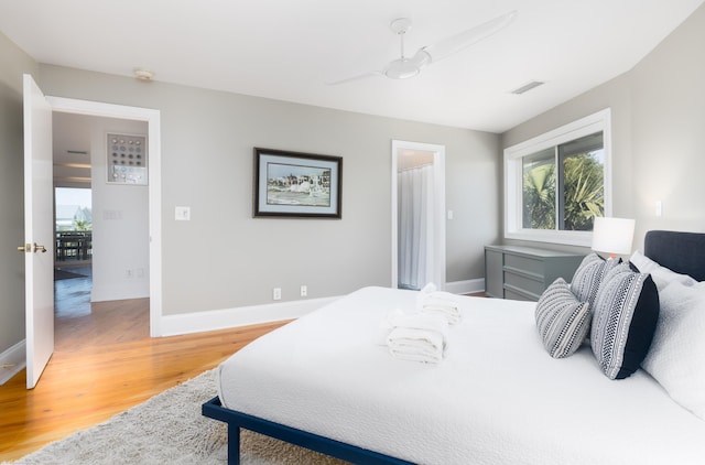 bedroom featuring baseboards, ceiling fan, light wood-style floors, and visible vents