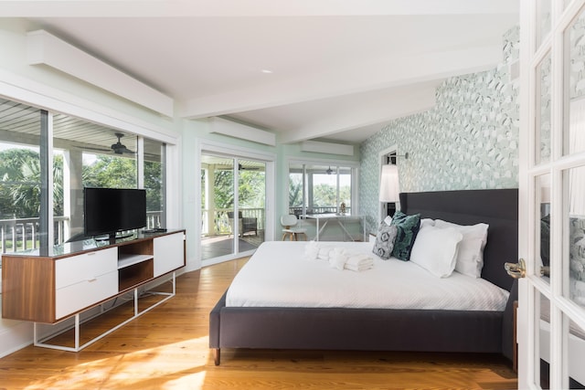bedroom with wallpapered walls, beam ceiling, wood finished floors, and access to exterior