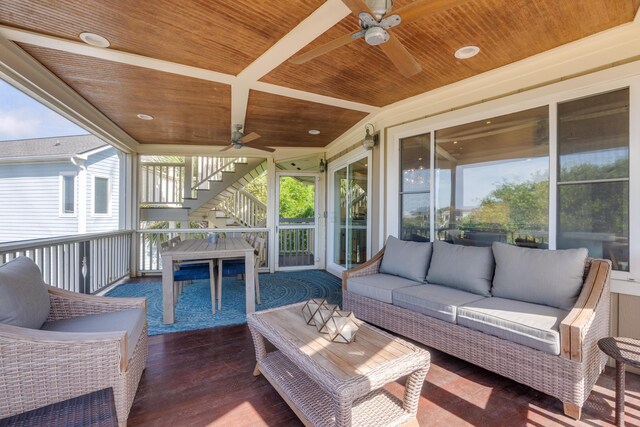 sunroom featuring ceiling fan and an outdoor living space