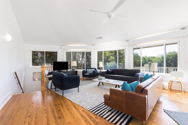 living area featuring lofted ceiling, a wealth of natural light, and light wood-style flooring