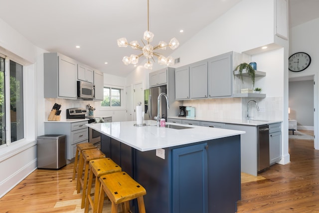 kitchen featuring an inviting chandelier, a sink, open shelves, appliances with stainless steel finishes, and decorative backsplash