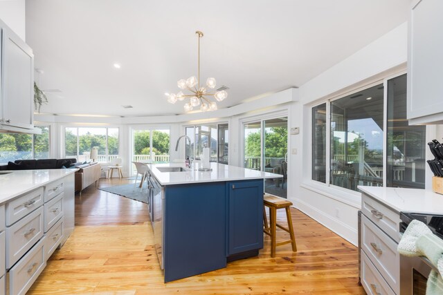 kitchen featuring stainless steel electric range oven, light countertops, light wood-type flooring, and a sink