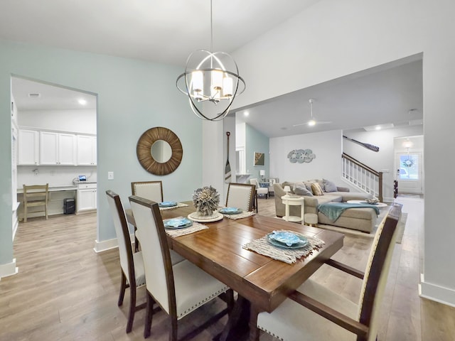 dining area featuring light hardwood / wood-style flooring, a notable chandelier, and vaulted ceiling