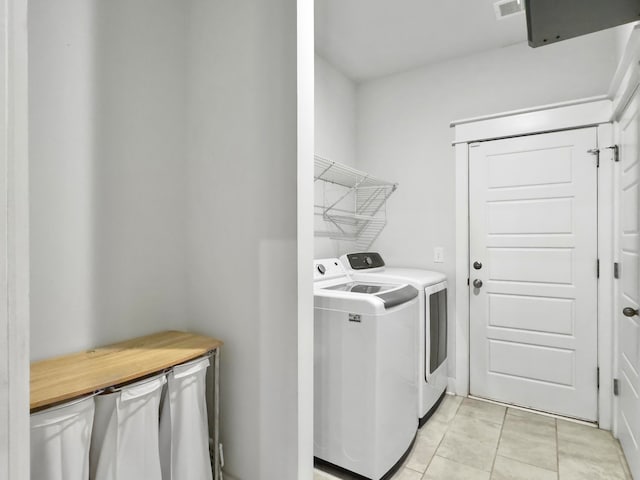 washroom with washer and dryer and light tile patterned floors