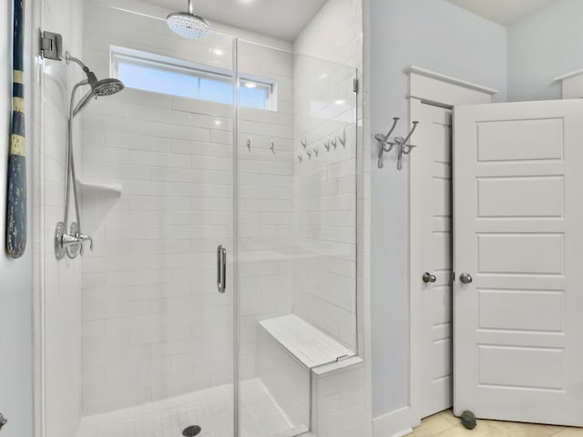 bathroom with tile patterned floors and a shower with door