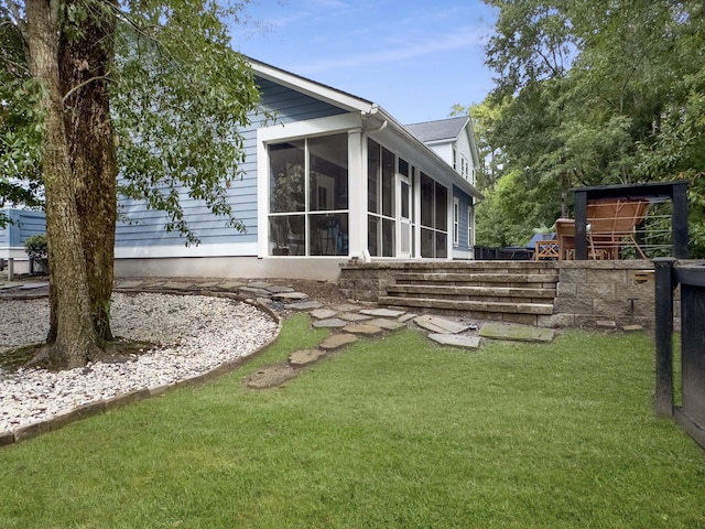 back of property featuring a lawn and a sunroom