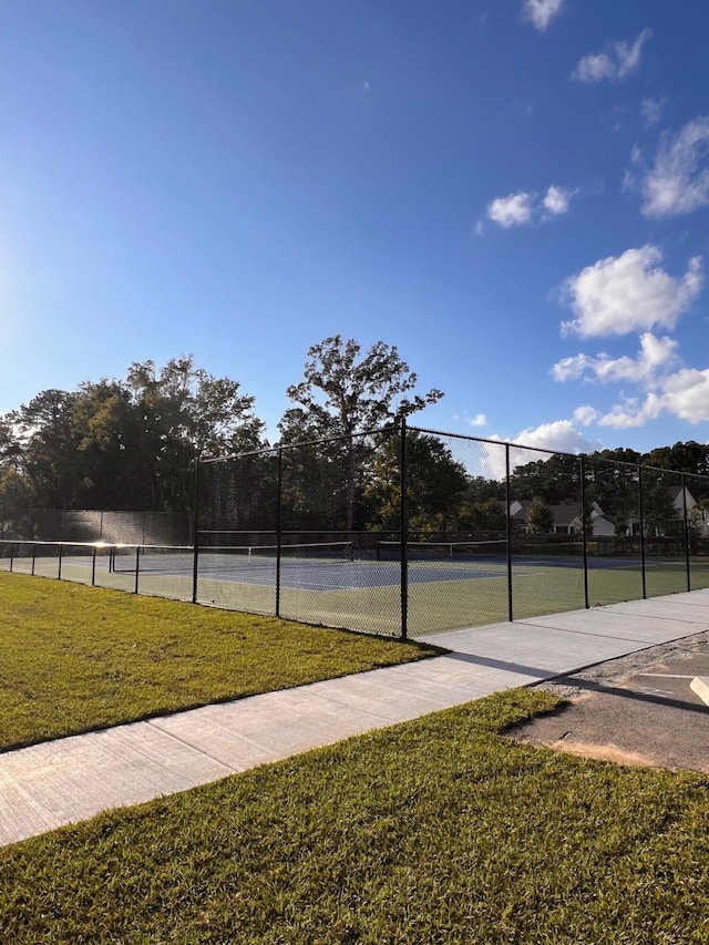 view of sport court featuring a lawn