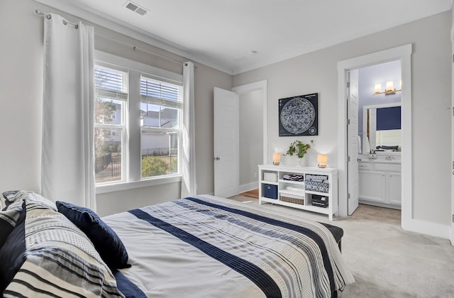 bedroom featuring visible vents, ensuite bath, light carpet, and baseboards