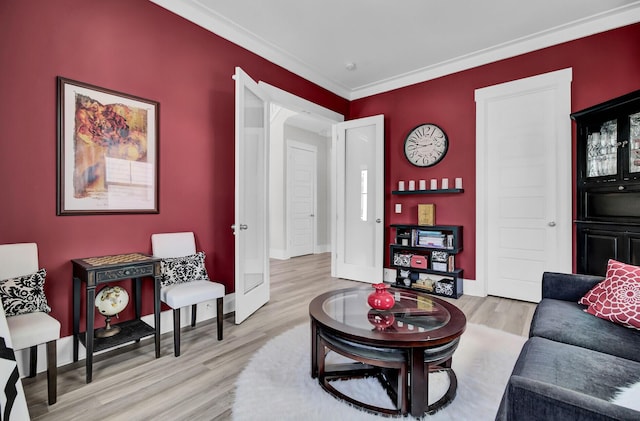 living room with light wood-style floors, crown molding, and baseboards