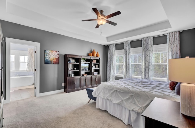 bedroom with carpet floors, multiple windows, and a raised ceiling