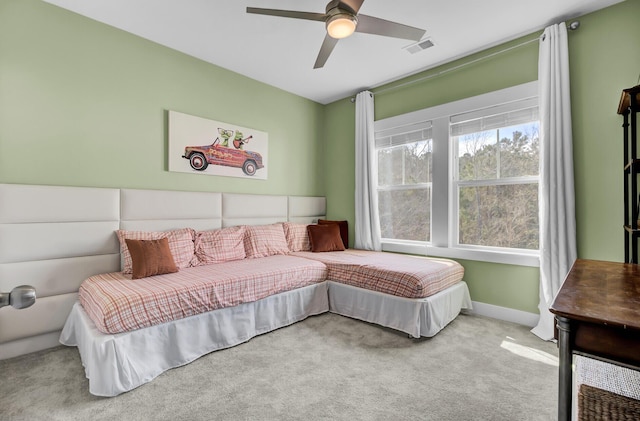 bedroom with ceiling fan, visible vents, baseboards, and light colored carpet