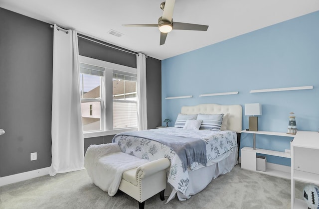 bedroom featuring baseboards, visible vents, a ceiling fan, and light colored carpet
