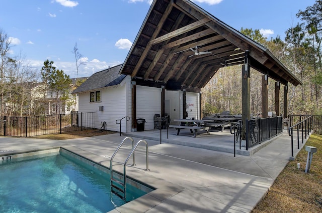 pool with a patio area and fence