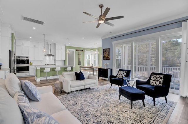 living room featuring light wood-style floors, ceiling fan, visible vents, and recessed lighting