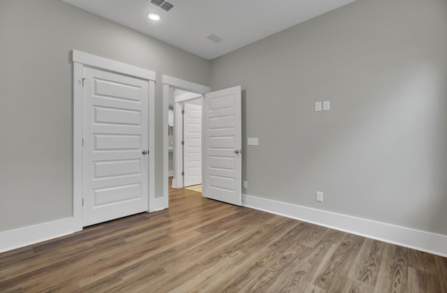 unfurnished bedroom with hardwood / wood-style floors and a closet