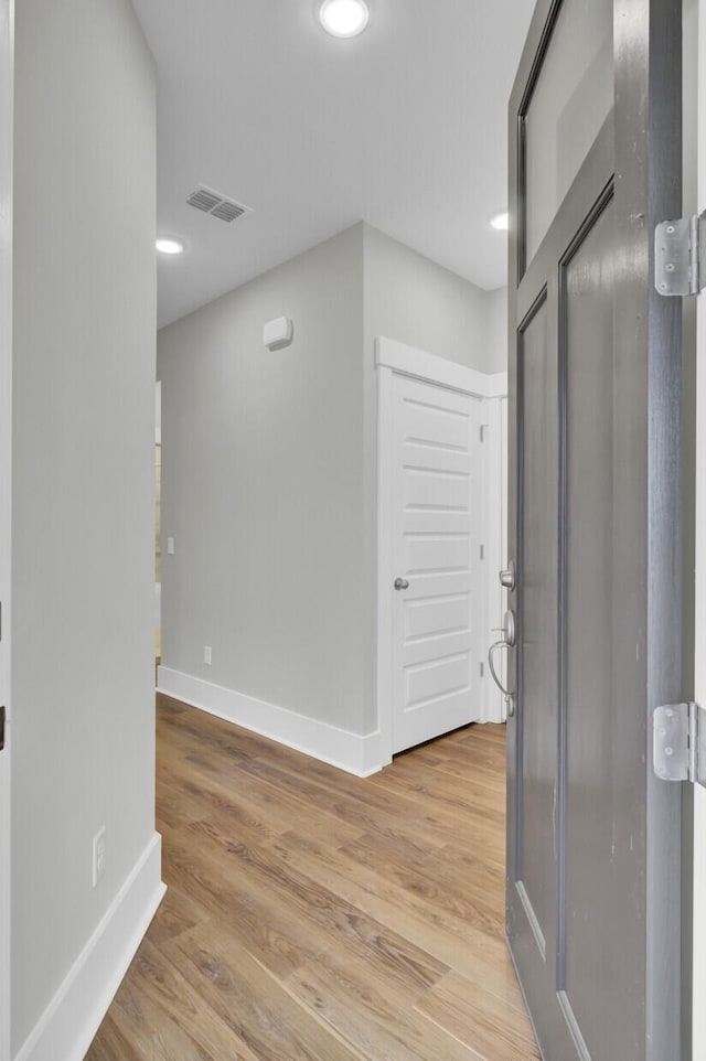 corridor with hardwood / wood-style flooring