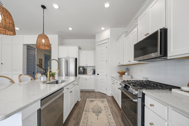 1713 Banning St, Mount Pleasant, SC 29466 - kitchen featuring appliances with stainless steel finishes, tasteful backsplash, white cabinets, dark wood finished floors, and pendant lighting