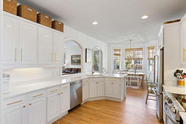 601 King Haven Ln, Johns Island, SC 29455 - kitchen featuring appliances with stainless steel finishes, a sink, white cabinets, light wood-type flooring, and a chandelier