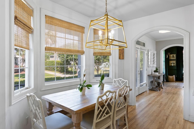 601 King Haven Ln, Johns Island, SC 29455 - dining space featuring arched walkways, a chandelier, plenty of natural light, light wood-style flooring, and crown molding