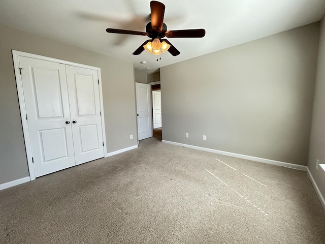 unfurnished bedroom featuring a ceiling fan, carpet, a closet, and baseboards