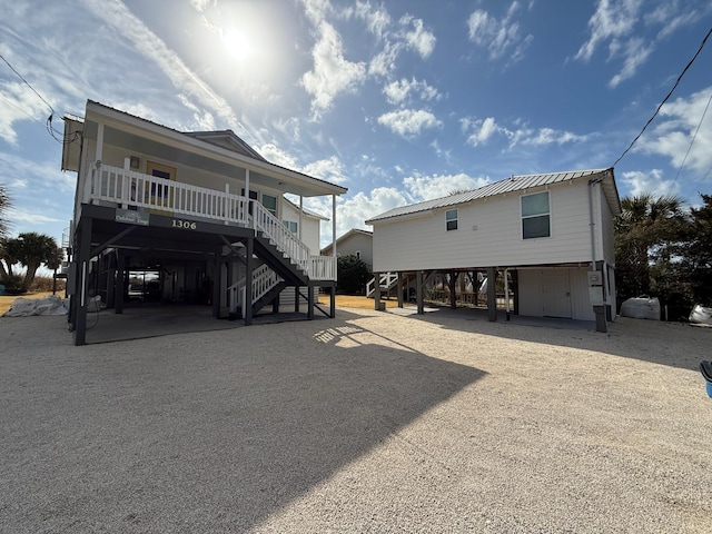 back of property featuring a carport and covered porch