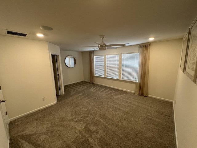 spare room featuring dark colored carpet, recessed lighting, visible vents, ceiling fan, and baseboards