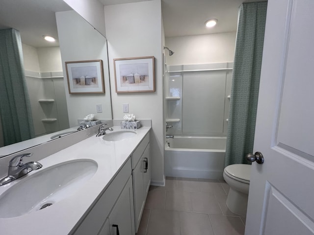 full bath with double vanity, a sink, toilet, and tile patterned floors