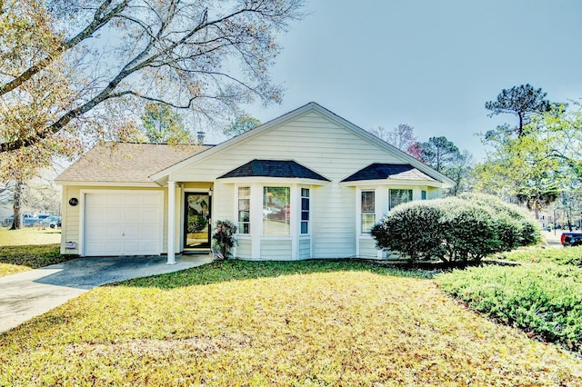 view of front of house with a garage, concrete driveway, a front yard, and a shingled roof