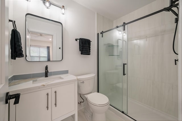 bathroom featuring toilet, vanity, and a shower with shower door