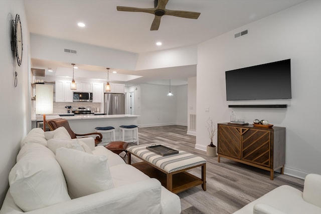 living room with ceiling fan and light hardwood / wood-style floors