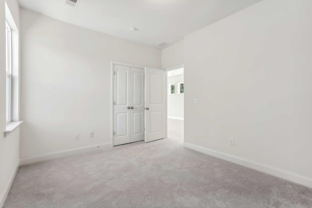 unfurnished room featuring light carpet