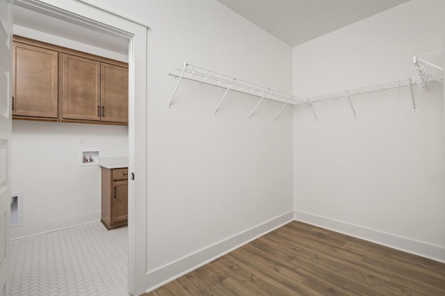 walk in closet with dark wood-type flooring