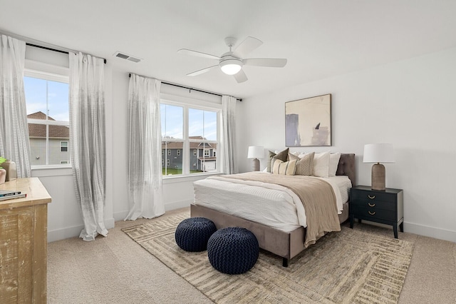 carpeted bedroom with visible vents, ceiling fan, and baseboards