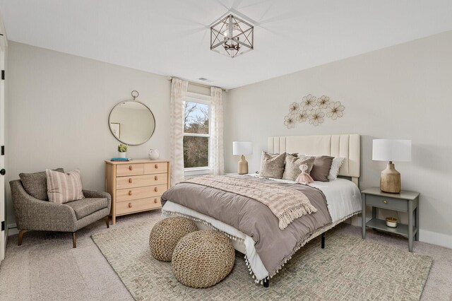 carpeted bedroom featuring a notable chandelier