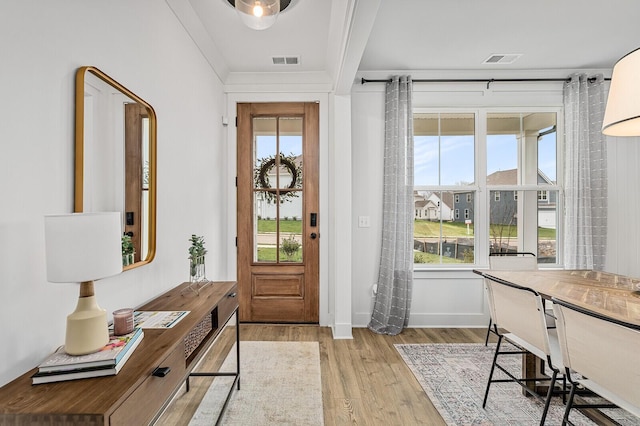 foyer entrance featuring visible vents, plenty of natural light, and light wood-type flooring