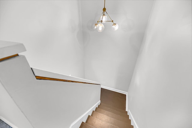 staircase with baseboards and wood finished floors