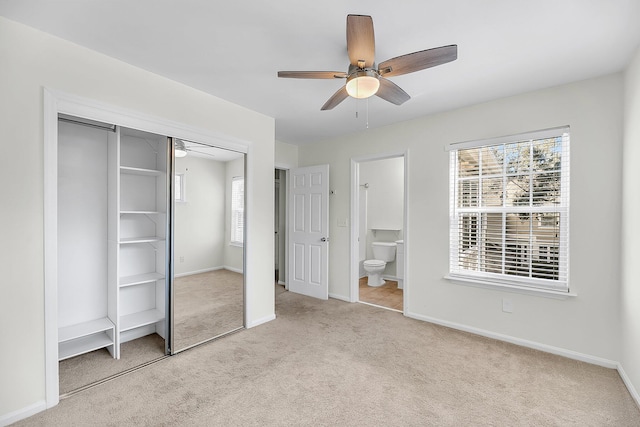 unfurnished bedroom featuring ensuite bathroom, a ceiling fan, a closet, carpet, and baseboards