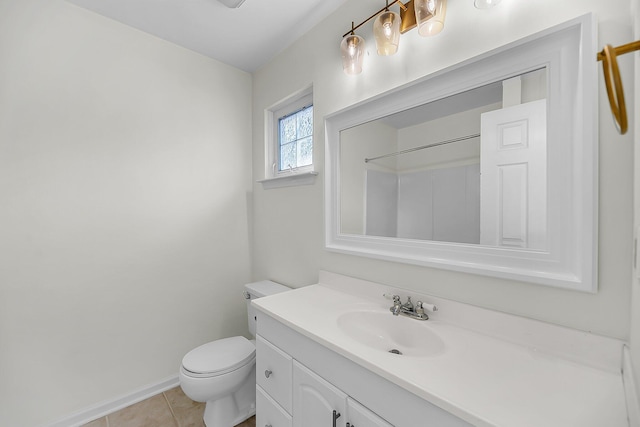 bathroom with tile patterned floors, toilet, vanity, and baseboards