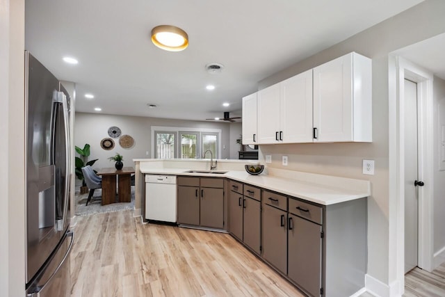 1161 Monaco Dr, Mount Pleasant, SC 29464 - kitchen featuring white dishwasher, stainless steel refrigerator, a peninsula, light countertops, and light wood-style flooring