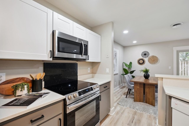 1161 Monaco Dr, Mount Pleasant, SC 29464 - kitchen featuring stainless steel appliances, light wood-style flooring, light countertops, white cabinets, and recessed lighting