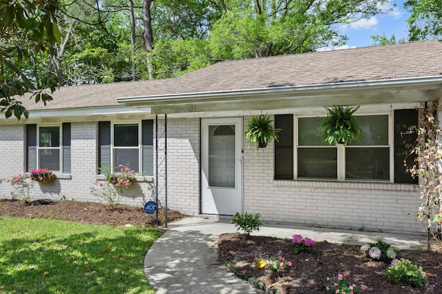 view of front of property featuring brick siding and a shingled roof