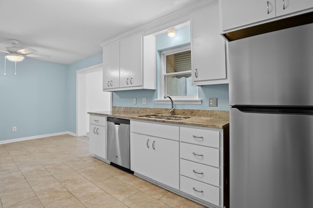kitchen featuring light stone countertops, baseboards, ceiling fan, a sink, and stainless steel appliances