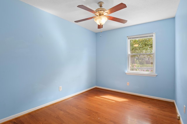 unfurnished room featuring baseboards, ceiling fan, and wood finished floors