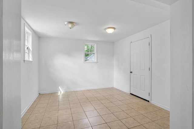 unfurnished room featuring baseboards and light tile patterned floors