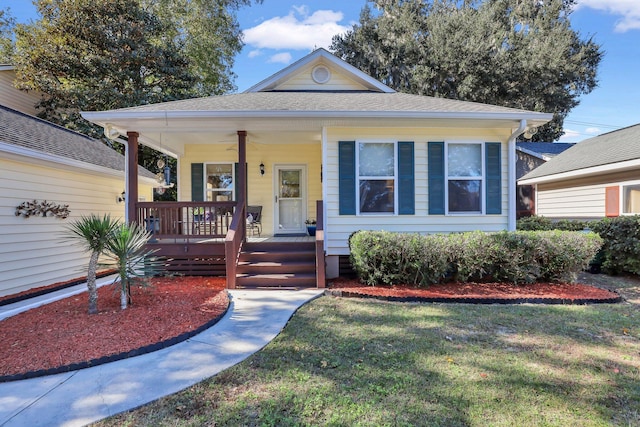 bungalow-style home with a front yard, ceiling fan, and covered porch