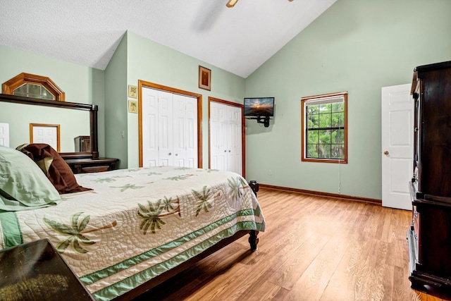 209 Jungle Rd, Edisto Beach, SC 29438 - bedroom with two closets, light wood-style floors, baseboards, high vaulted ceiling, and ceiling fan