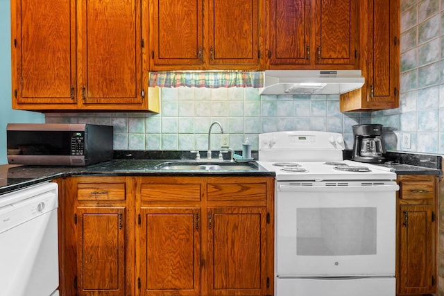 209 Jungle Rd, Edisto Beach, SC 29438 - kitchen featuring under cabinet range hood, white appliances, a sink, and dark countertops